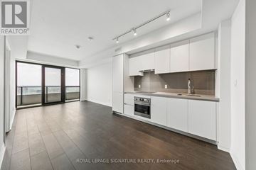 Mississauga (City Centre) condo for rent - A spacious kitchen with white cabinets and a dark countertop.