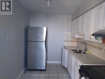 Toronto (Dorset Park) condo for rent - A kitchen with a stainless steel refrigerator and white cabinets.