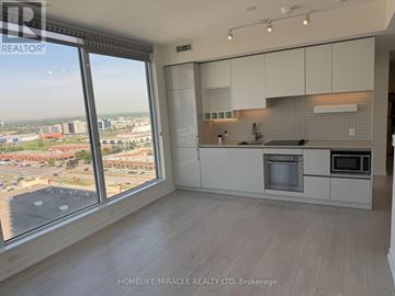 Vaughan (Vaughan Corporate Centre) condo for rent - A kitchen with white cabinets and a view of the city.