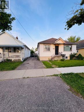 St. Catharines (Western Hill) apartment for rent - A residential street with houses on both sides and a sidewalk in the foreground.
