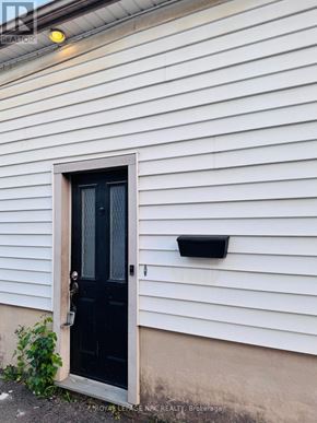 St. Catharines (Western Hill) apartment for rent - A black door is on a white siding house.