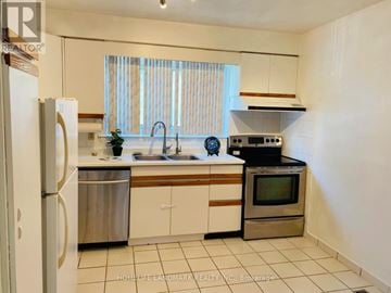 Toronto (L'amoreaux) townhouse for rent - A kitchen with white cabinets and a stainless steel refrigerator.