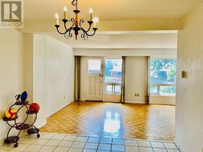 Toronto (L'amoreaux) townhouse for rent - A room with a chandelier, a table with a vase and a bowl, and a brokerage logo on the wall.