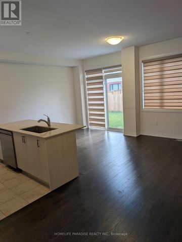 Cambridge townhouse for rent - A kitchen with a sink and cabinets in a room with a sliding glass door.