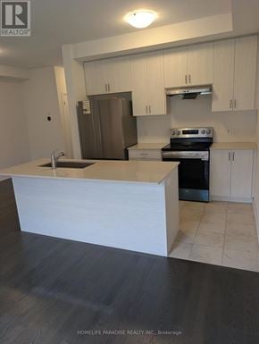 Cambridge townhouse for rent - A kitchen with a white counter top and a stainless steel refrigerator.