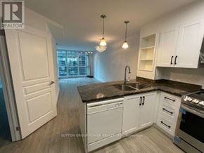 Toronto (Waterfront Communities) condo for rent - A kitchen with white cabinets and a black countertop.