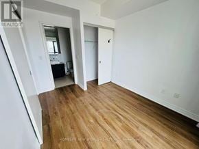 Toronto (Church-Yonge Corridor) condo for rent - A room with wooden flooring and white walls, with a doorway leading to another room.