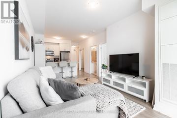 Hamilton (Waterdown) condo for rent - A modern living room with a grey sofa and a white television.