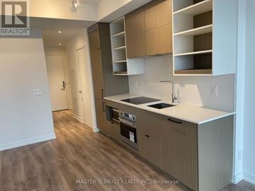 Toronto (Bay Street Corridor) condo for rent - A kitchen with wooden cabinets and a white countertop.