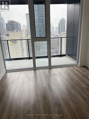 Toronto (Bay Street Corridor) condo for rent - A room with a view of the city through a glass door.