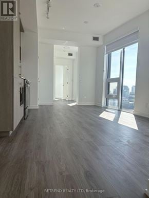 Toronto (Church-Yonge Corridor) condo for rent - A spacious room with wood flooring and a view of the city through large windows.