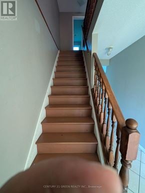 London South (South X) apartment for rent - A staircase with a wooden handrail and steps leading to a blue door.