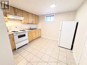 Toronto (Newtonbrook East) apartment for rent - A kitchen with white appliances and wooden cabinets.