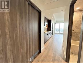 Toronto (Bayview Village) condo for rent - A modern interior space with wooden walls and a glass door leading to another room.