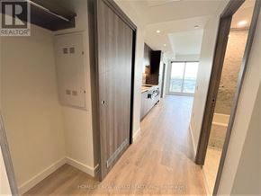 Toronto (Bayview Village) condo for rent - A hallway with a wooden floor and a white door.