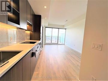 Toronto (Bayview Village) condo for rent - A modern kitchen with dark wood cabinets and a marble backsplash.