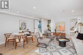 Toronto (Dovercourt-Wallace Emerson-Junction) apartment for rent - A living room with a white couch, a coffee table, and a dining table with chairs.