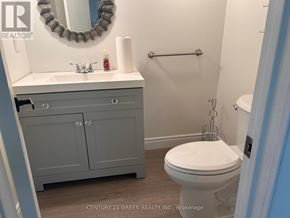 Mississauga (Malton) apartment for rent - A bathroom with a toilet, sink, and mirror.