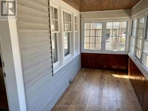 St. Catharines (Downtown) apartment for rent - A room with wooden floors and white walls with windows.