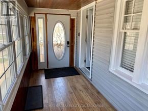 St. Catharines (Downtown) apartment for rent - A hallway with a wooden floor, white walls, and a stained glass door.