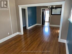 St. Catharines (Downtown) apartment for rent - A room with wooden flooring and a chandelier.