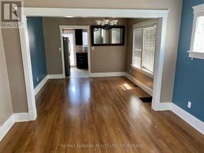St. Catharines (Downtown) apartment for rent - A room with wooden flooring and a large mirror on the wall.