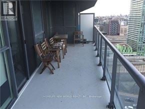Toronto (Waterfront Communities) condo for rent - A balcony with chairs and a table overlooking a cityscape.