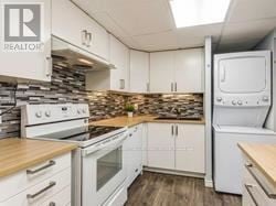 Mississauga (Mississauga Valleys) condo for rent - A kitchen with white cabinets and a stone backsplash.