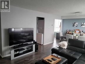 Mississauga (Mississauga Valleys) condo for rent - A living room with a television and a black leather couch.