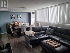 Mississauga (Mississauga Valleys) condo for rent - A living room with a black leather couch and a wooden coffee table.