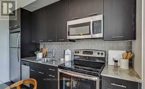 Toronto (Woodbine Corridor) condo for rent - A modern kitchen with a dining table and chairs.