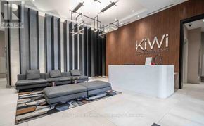 Hamilton (Beasley) condo for rent - A modern office lobby with a reception desk and a large couch.