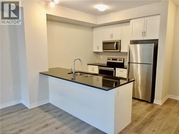 Stoney Creek townhouse for rent - A modern kitchen with a black countertop and stainless steel appliances.