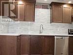 Vaughan (Patterson) apartment for rent - A kitchen with brown cabinets and a white backsplash.