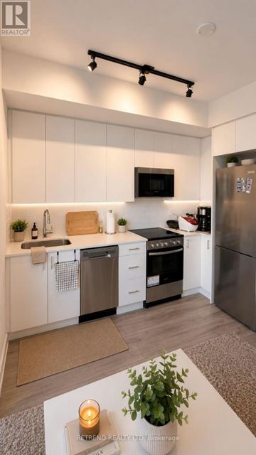 Toronto (Willowdale West) condo for rent - A modern kitchen with white cabinets and stainless steel appliances.