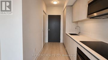 Toronto (Lawrence Park North) condo for rent - A kitchen with a sink, stove, and microwave.