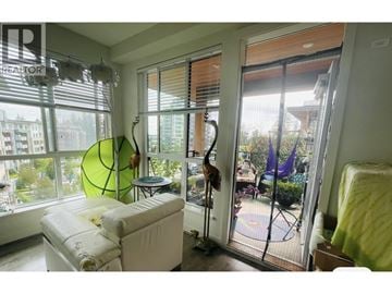 Vancouver apartment for rent - A living room with a white couch and a large window with a view of the city.