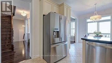 Richmond Hill (Oak Ridges) apartment for rent - A kitchen with a stainless steel refrigerator and a chandelier hanging from the ceiling.