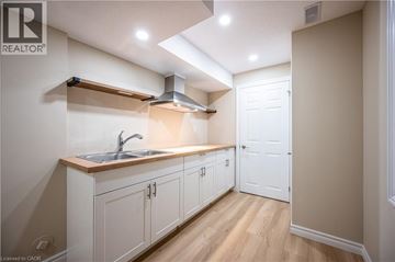 Kitchener apartment for rent - A kitchen with white cabinets and a wooden countertop.