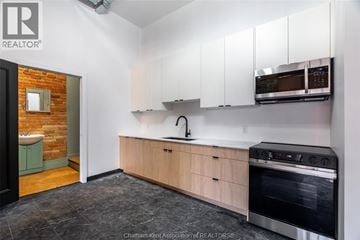 Chatham apartment for rent - A kitchen with white cabinets and a brick wall.