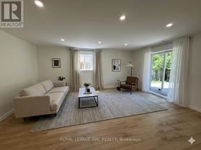 St. Catharines (Burleigh Hill) apartment for rent - A living room with a couch, a coffee table, and a lamp.