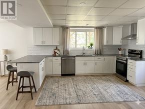 St. Catharines (Burleigh Hill) apartment for rent - A kitchen with white cabinets and a rug on the floor.