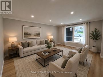 St. Catharines (Burleigh Hill) apartment for rent - A well-lit living room with a large sofa, a coffee table, and a painting on the wall.