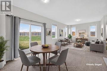 Hamilton (Stoney Creek) townhouse for rent - A living room with a dining table and grey couches.