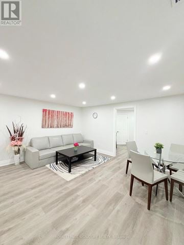 Mississauga (Applewood) apartment for rent - A living room with a grey sofa, a glass table and a white chair.
