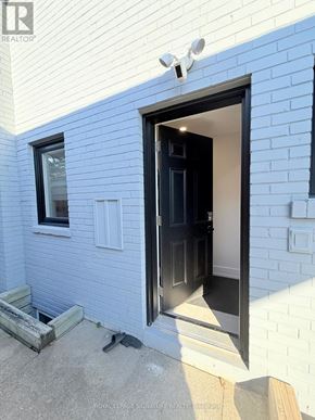 Mississauga (Applewood) apartment for rent - A white brick house with a black door and window.