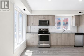 Toronto (Yorkdale-Glen Park) townhouse for rent - A modern kitchen with a stove top oven and microwave above the counter.