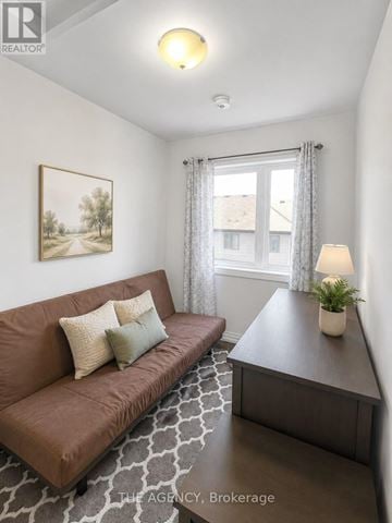 Brantford townhouse for rent - A living room with a brown couch and a painting on the wall.