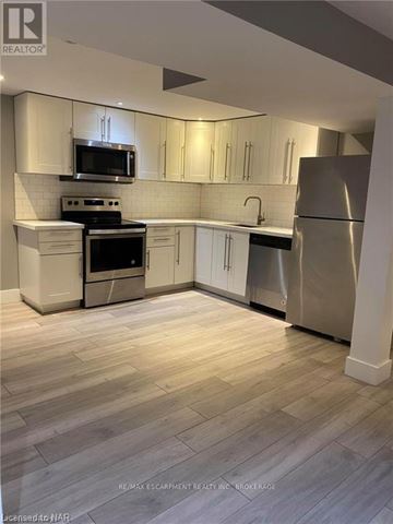 Hamilton (Stoney Creek Mountain) apartment for rent - A kitchen with white cabinets and a refrigerator.