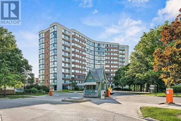 Oakville (Cp College Park) condo for rent - A large building with a glass facade is surrounded by trees and a small gazebo is in front of it.